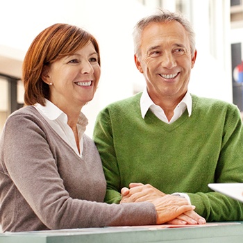 Smiling older man and woman at reception desk