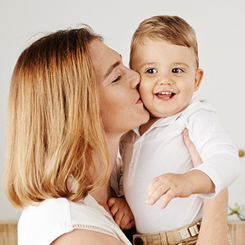 Mother kissing baby on cheek