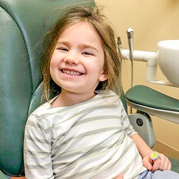 child in dental office receiving dental sealants