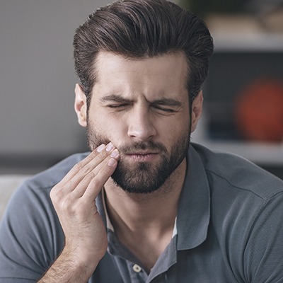 Man holding jaw in pain