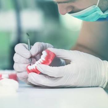 A dentist working on the teeth for a denture.