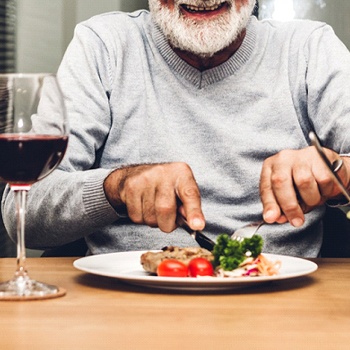 older man eating steak 