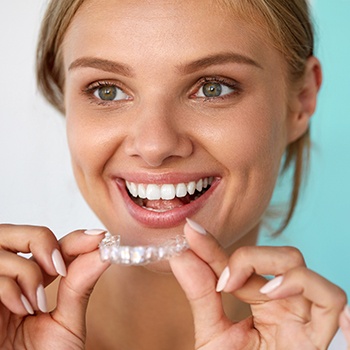 Woman putting her Invisalign tray in place