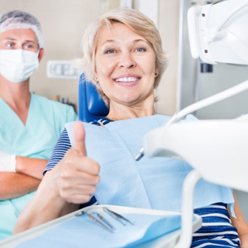 Happy dental patient making a thumbs-up gesture