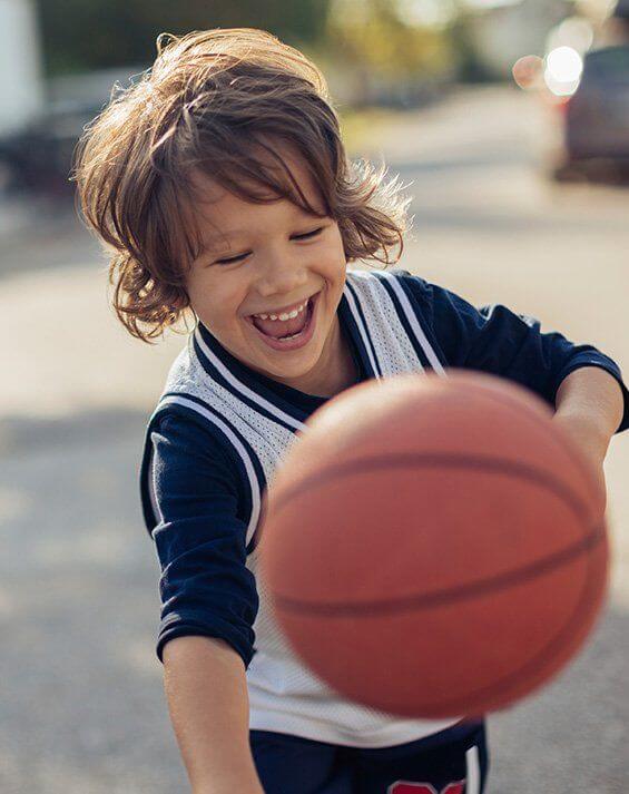 Laughing child playing basketball