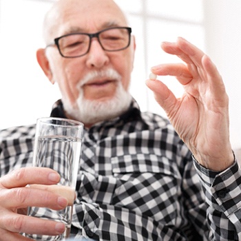 older man about to take pill for oral conscious sedation