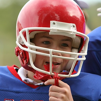 Teen boy placing red mouthguard