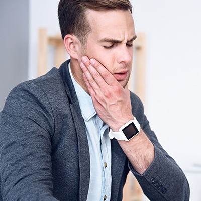 Man holding jaw in pain