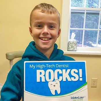 kid dental patient smiling with waterlase sign