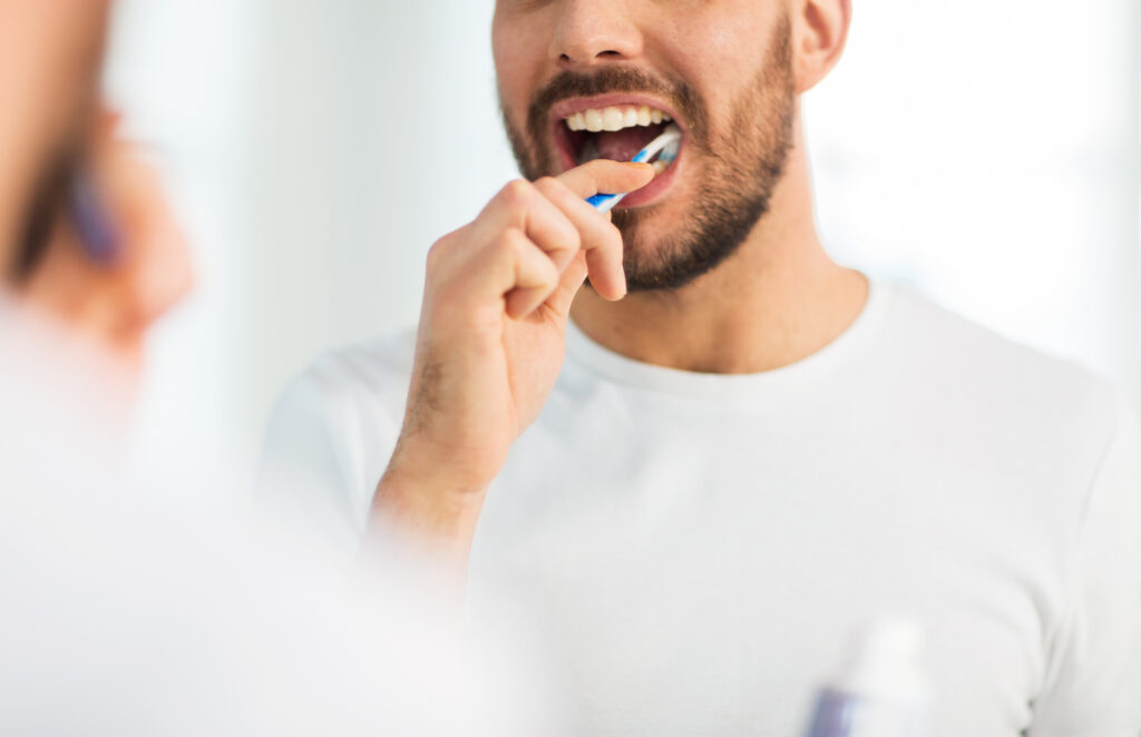 Patient brushing their teeth before getting cosmetic dentistry